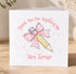 A white card with a pink bow and a pencil, along with the text "Thank You For Teaching Me" and "Mrs Turner" written on it.