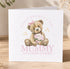 A greeting card with a teddy bear holding flowers and the text "Happy Mother's Day Mummy Love from summer" printed on it.