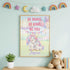 a framed poster with a unicorn and a message encouraging bravery and kindness, along with a teddy bear and some books on a shelf.