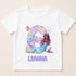 A white t-shirt with a design featuring a mermaid character and the number 6.