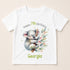 A white t-shirt with a printed design featuring a koala bear and some greenery. The text on the t-shirt reads "Happy 7th Birthday Georgia".