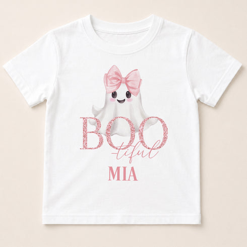 A white t-shirt with a graphic design featuring a ghost character wearing a pink bow and the text "BOO tful MIA" printed on it.