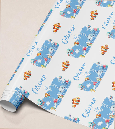 The image is a roll of wrapping paper with a repeating pattern of the name "Olivier" and various sea creatures, such as fish and octopuses, printed on it.