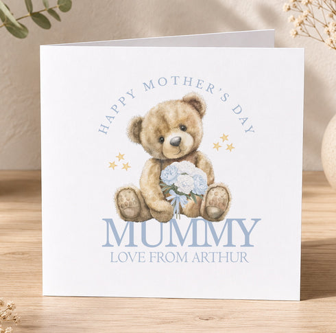 A greeting card with a teddy bear holding flowers and the text "Happy Mother's Day Mummy Love from Arthur" printed on it.