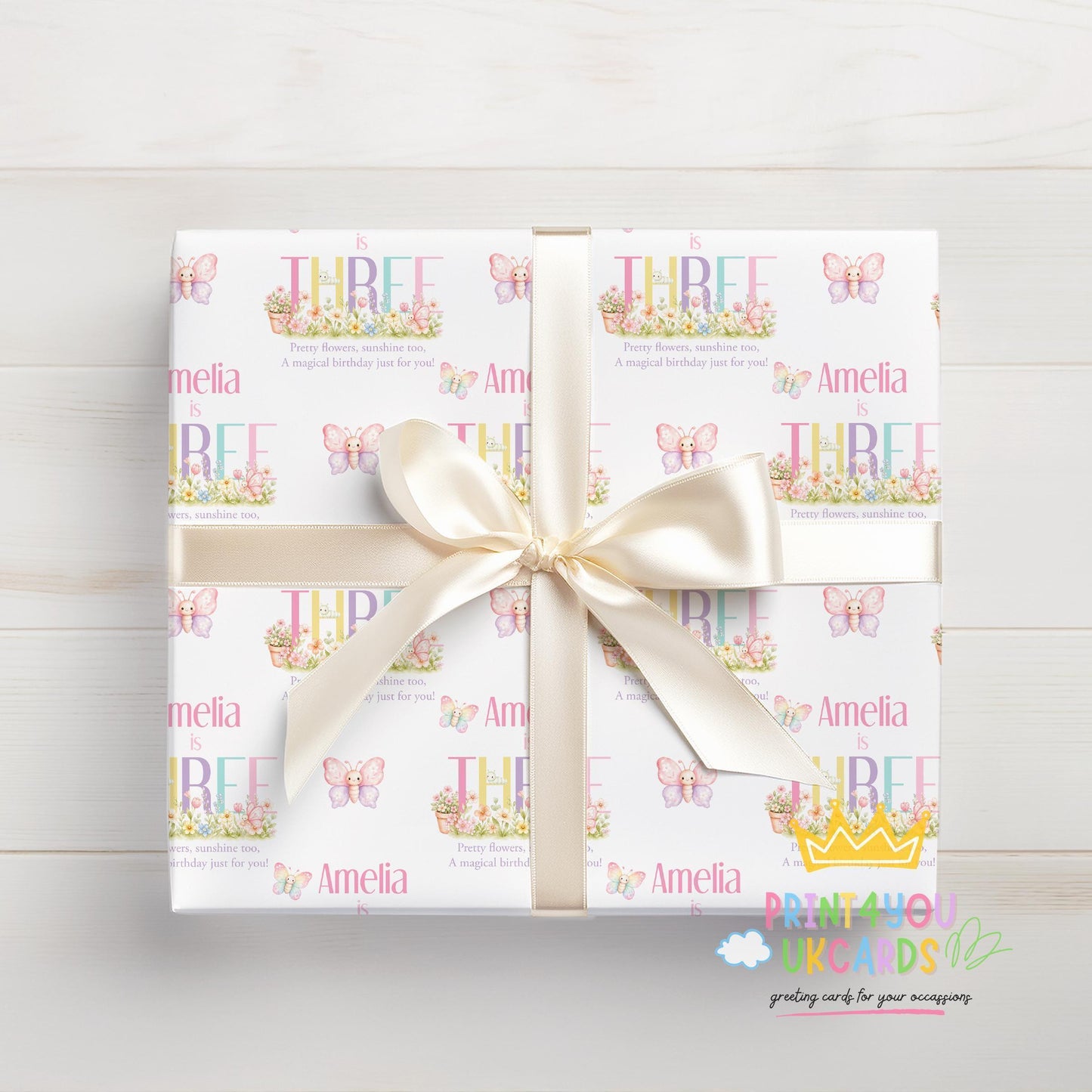 Gift box wrapped in personalised butterfly wrapping paper printed with the name Amelia, finished with white ribbon.