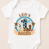 A white baby onesie with a graphic design featuring a cowboy hat, a horseshoe, and the text "LEO'S 1ST RODEO" printed on it.