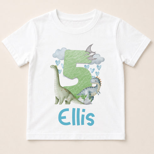 A white t-shirt with a graphic design featuring a green dinosaur and clouds, along with the text "Ellis" below the design.