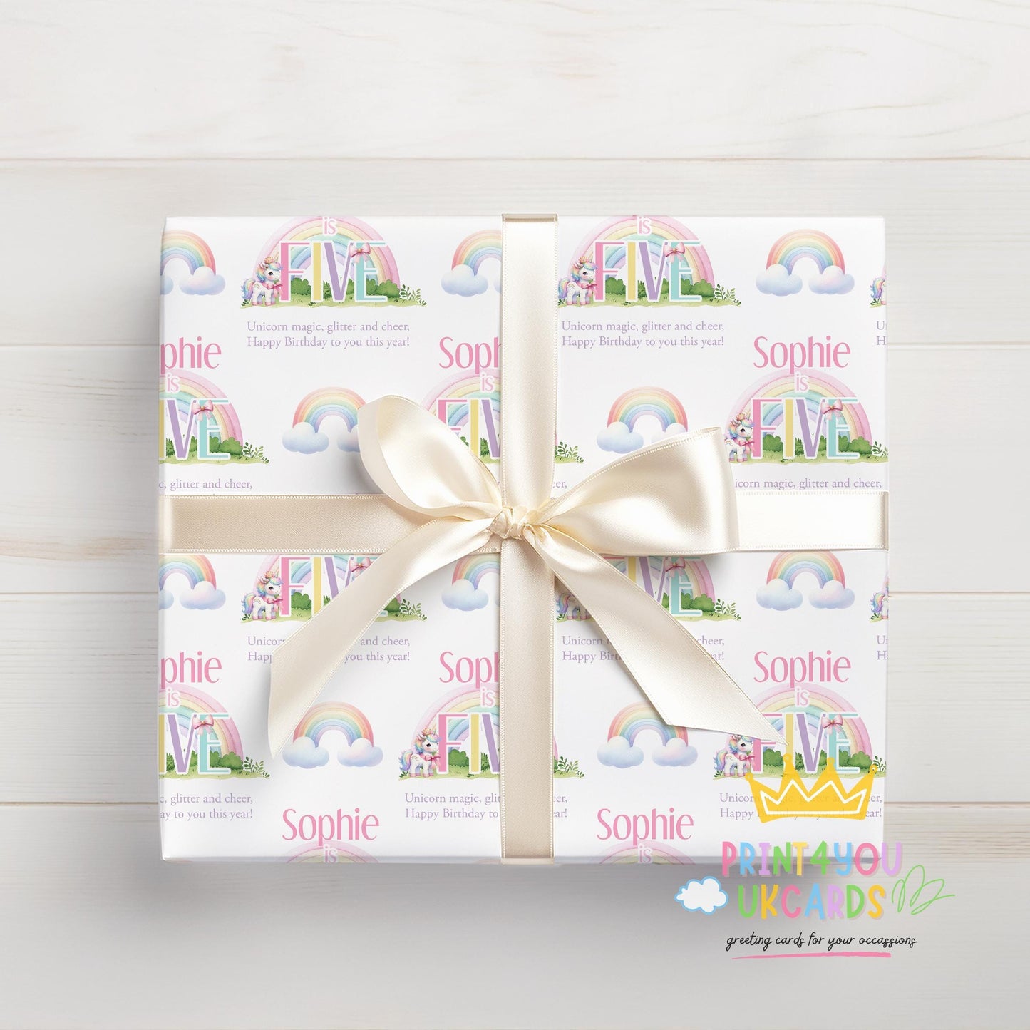 Personalised rainbow unicorn birthday wrapping paper wrapped around a gift