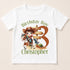 A white t-shirt with a cartoon image of a boy riding a horse and holding a sign that says "Birthday Boy Christopher".