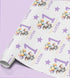 a roll of wrapping paper with a repeating pattern of elephants holding balloons and the name "Lottie" written on it.