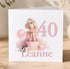 A birthday card with a picture of a smiling woman in a pink dress, surrounded by balloons and gifts, with the number 40 and the name Leanne displayed.