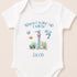 A white onesie with a personalized design for a baby's first birthday. The design includes a blue number 1, a dolphin, a starfish, and other marine life. The text above the design says "When I wake up I will be Jacob".