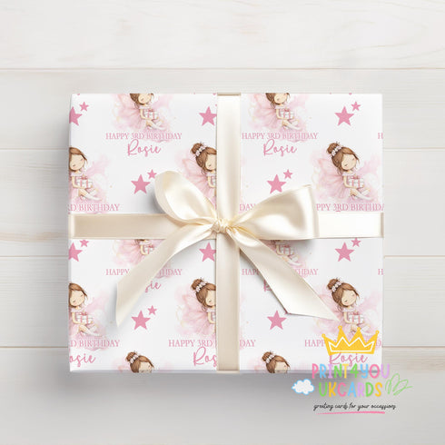 A gift box wrapped with a pink and white pattern featuring a princess and stars, tied with a white ribbon.