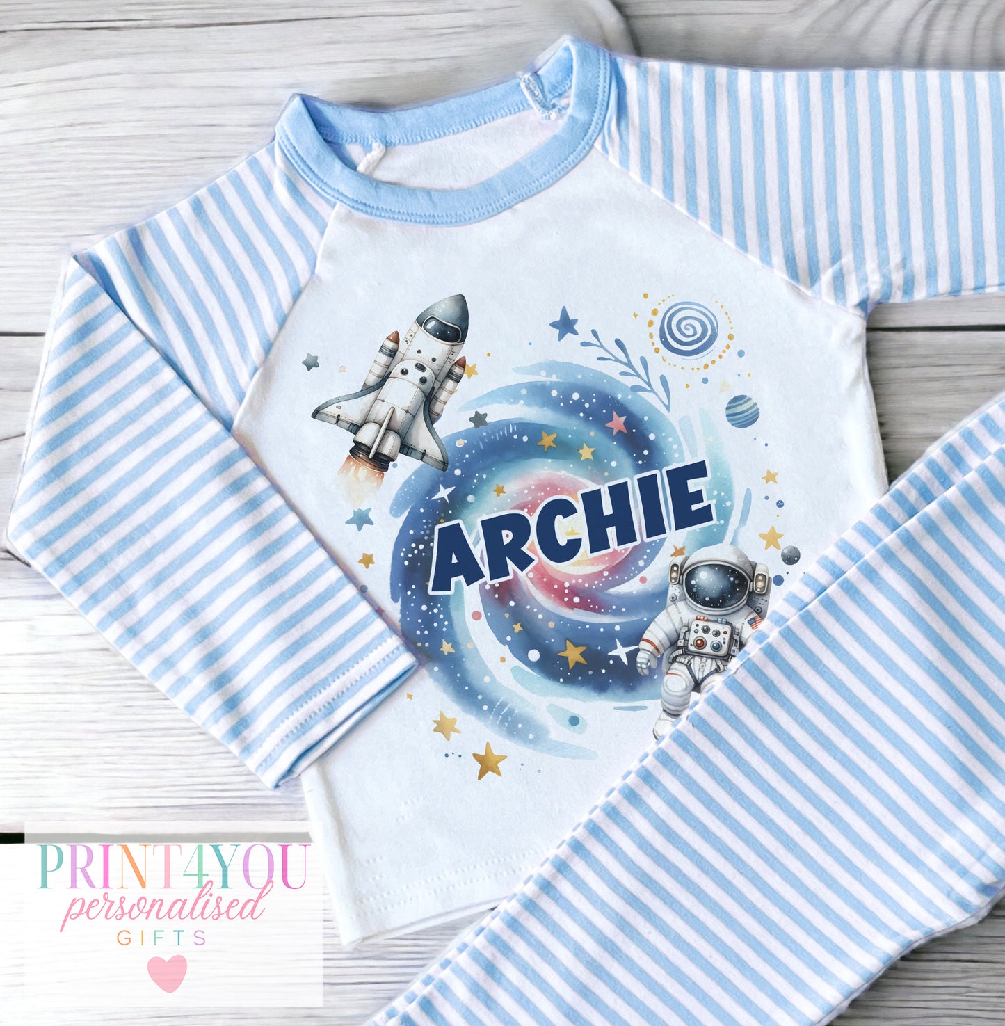 Personalised blue and white striped boys' pyjamas with a space design of rockets and planets, personalised with child's name