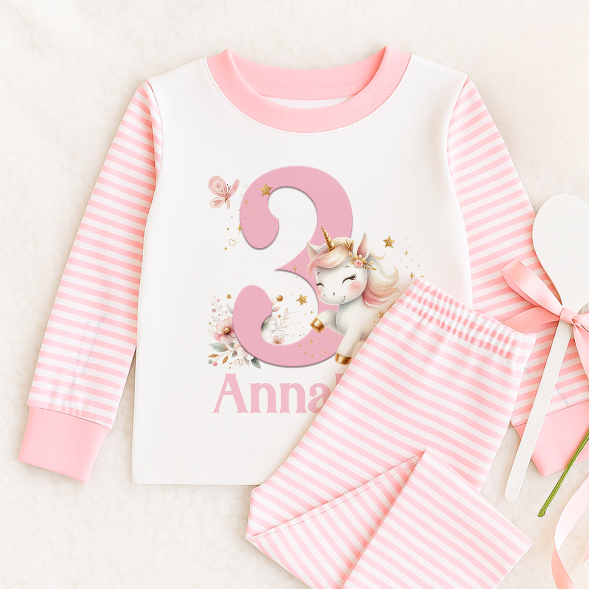 Personalised pink and white striped girls pyjamas with unicorn and number design, custom name printed on the top