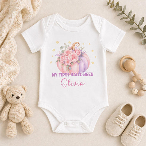 Personalised baby’s first Halloween white vest featuring a pastel pink and purple floral pumpkin, golden stars and baby’s name.