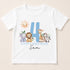 A white t-shirt with a graphic design featuring a blue number 4 surrounded by various cartoon animal characters, including a lion, giraffe, elephant, and zebra. The text "HAPPY BIRTHDAY Sam" is displayed below the number.