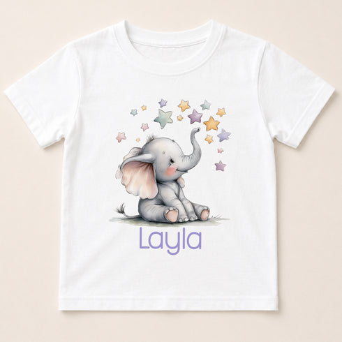 A white t-shirt with a printed image of a baby elephant surrounded by stars and the name "Layla" written below it.