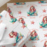 Close-up of personalised mermaid birthday wrapping paper with a repeating pastel mermaid, seashell and starfish pattern on premium white gift wrap.