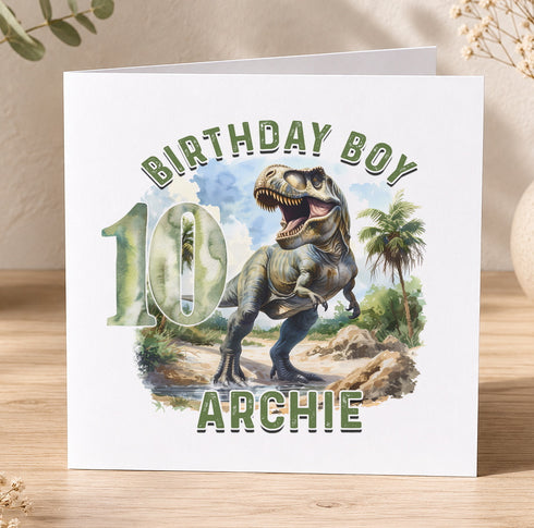 A birthday card featuring a dinosaur, specifically a T-Rex, with the number 10 and the name "Archie" written on it.