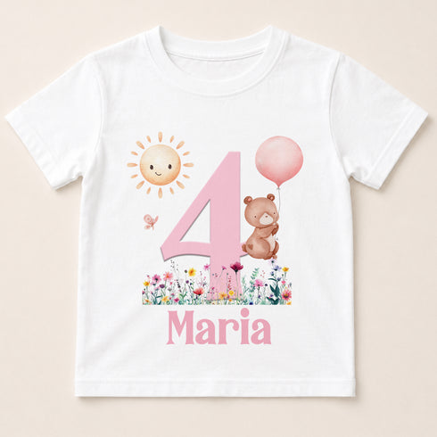 A white t-shirt with a pink number 4 and a pink balloon, along with a small brown bear holding a pink balloon. The text "4 Maria" is also present on the shirt.
