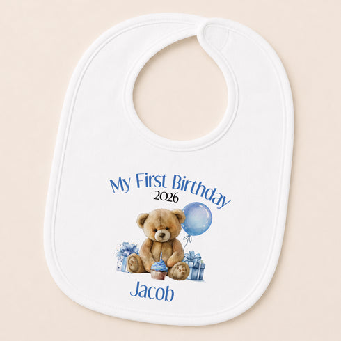 A white baby bib with a personalized design featuring a teddy bear and a blue balloon, along with the text "My First Birthday Jacob 2016".