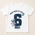 A white t-shirt with a graphic design featuring an astronaut and the number 6, along with the text "When I wake up I will be Rhys" printed on it.