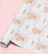 a roll of wrapping paper with a repeating pattern of a yellow duck holding balloons and the name "Abella" written on it.