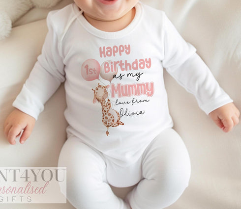 A white cotton baby sleepsuit with pink and black text reading Happy 1st Birthday As my Mummy love from and a name. Cute giraffe graphics holding a beige and pink balloon