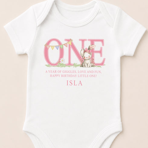 A white onesie with a pink bunny and the word "ONE" printed on it.