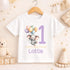 Personalised 1st birthday baby outfit with cute elephant, pastel balloons, purple number 1 and custom name, shown on bib, vest, sleepsuit, t-shirt and white pyjamas.