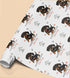 Personalised Dachshund birthday wrapping paper featuring a cute black and tan sausage dog puppy, custom name and birthday message with paw prints and dog toys.