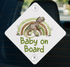 A white diamond-shaped sign with a cartoon dinosaur and a rainbow graphic, mounted on a car window.
