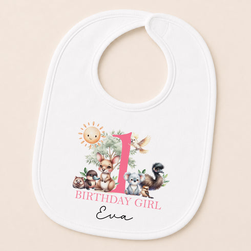 A white baby bib with a personalized design featuring a sun, animals, and the text "1 BIRTHDAY GIRL Eva".