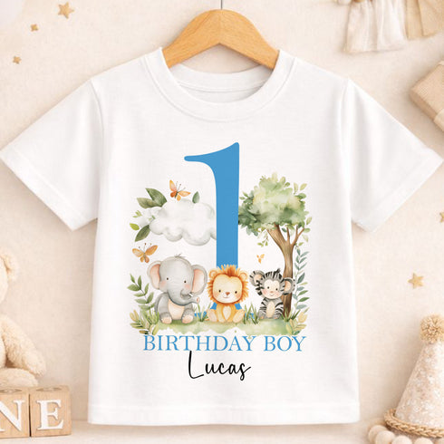 A white t-shirt with a graphic design featuring a blue number one surrounded by various animals, including an elephant, lion, and zebra, along with the text "BIRTHDAY BOY Lucas".
