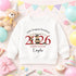 White children’s preschool graduation sweatshirt with a personalised red 2026 teddy bear graduate design, preschool name and child’s name on a pastel party background.