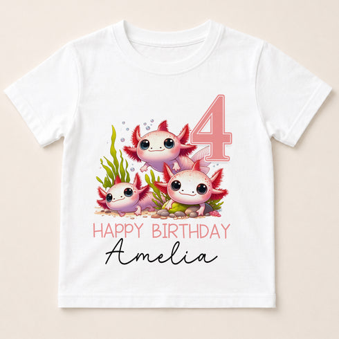 A white t-shirt with a graphic design featuring three cartoon axolotls, which are aquatic salamanders, along with the text "Happy Birthday Amelia" and the number "4".