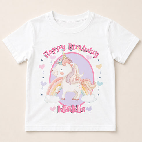 A white t-shirt with a cartoon unicorn and a birthday message printed on it.