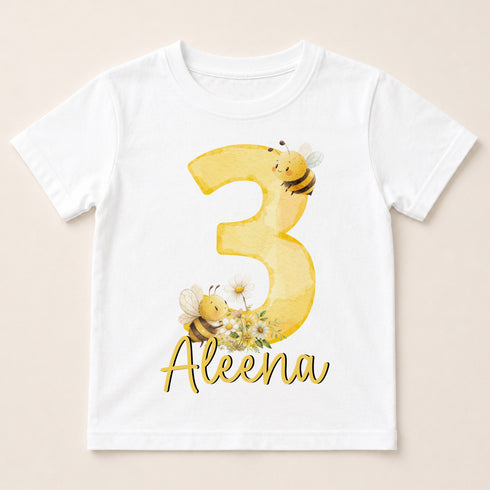 A white t-shirt with a yellow number 3 and a bee design, along with the name "Alena" written below it.