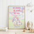 a framed poster with a unicorn and a bunny, along with the text "Be Brave, Be Kind, Be You" and the name " Jessica". The poster is displayed on a white wall, and there are some stuffed animals and books in the foreground.