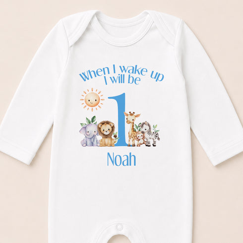 A white onesie with a personalized message and illustrations of various animals, including a lion, giraffe, elephant, and zebra.