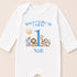 A white onesie with a personalized message and illustrations of various animals, including a lion, giraffe, elephant, and zebra.