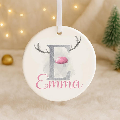 A white ornament with a pink and silver letter "E" and a pink reindeer antler design, with the name "Emma" written below it.