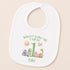 A white baby bib with a personalized design featuring a sun, a dragon, and a dinosaur, along with the text "When I wake up I will be Luke".