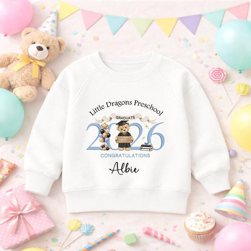 White children’s sweatshirt featuring a personalised blue 2026 teddy bear preschool graduation design with a nursery name and child’s name.