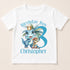 A white t-shirt with a graphic design featuring a dinosaur wearing a crown and the text "Birthday Boy Christopher" along with a number 3.
