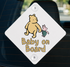 A diamond-shaped sign with a cartoon image of a bear and a piggy piggybacking on the back of a car.