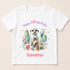 A white t-shirt with a printed design featuring a meerkat surrounded by cacti and flowers, along with the text "Happy 6th Birthday Savanna".