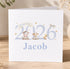 A white greeting card with a design featuring a cow, a sheep, and a duck, along with the text "BORN IN 2026 Jacob".