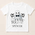 A white t-shirt with a graphic design featuring a ghost character wearing a bow tie, surrounded by bats, and the text "Too Cute to Spook" and "Spenser" below.